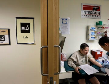 Loan Truong, left, who is Vietnamese, has blood drawn by Rechyle Torio, right, a phlebotomist, Friday, March 1, 2013 at International Community. (AP Photo/Ted S. Warren)