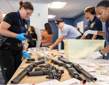 Police officer handling confiscated guns.