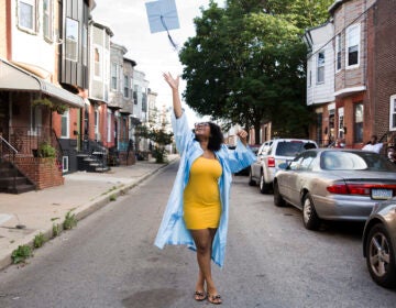 Aliah Harris, 18, throws her graduation cap in celebration on her dad's South Philly block on June 10, 2020. (Rachel Wisniewski for WHYY)