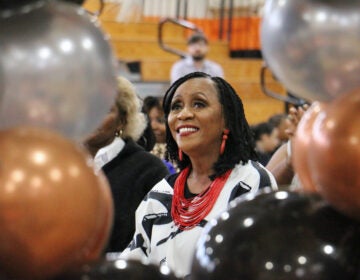 Retired Philadelphia teacher Joyce Abbott is framed by balloons during a celebration of her 27-year career, held at Overbrook High School. (Emma Lee/WHYY)