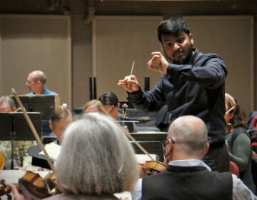 Andrew Samlal conducts the orchestra.