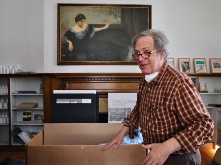 Sid Sachs packs up beneath a painting of Christine Wetherill Stevenson