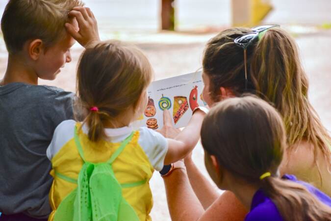 A teacher and children reading together