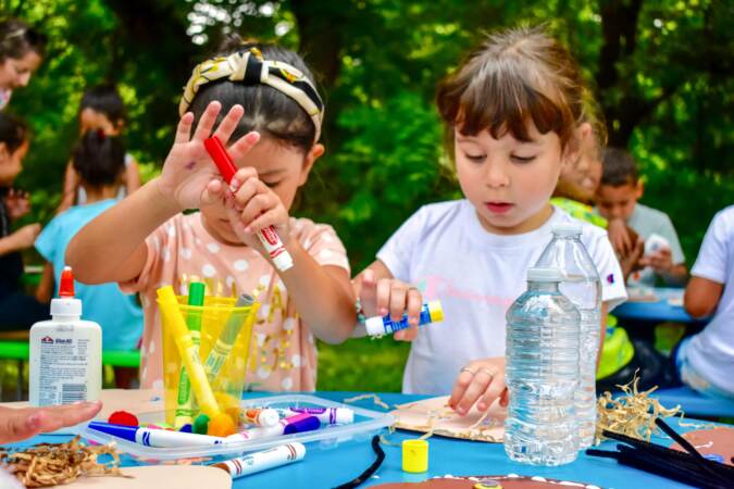 Two young girls coloring outside