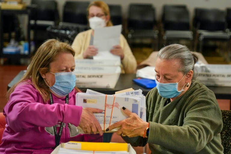 Bernadette Witt, left, and JoAnn Bartlett, right, process and double-check mail ballots