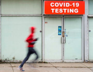 Person running in front of a covid testing site.