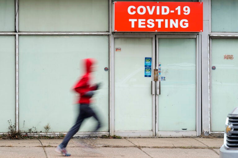 Person running in front of a covid testing site.