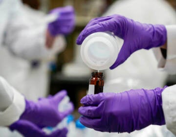 File photo: Eva Stebel, water researcher, pours a water sample into a smaller glass container for experimentation as part of drinking water and PFAS research at the U.S. Environmental Protection Agency Center For Environmental Solutions and Emergency Response, Feb. 16, 2023, in Cincinnati.