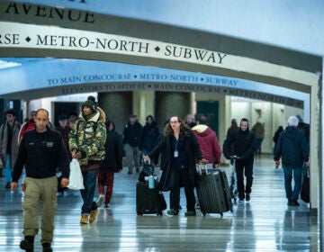 Travelers walk down a hallway in Grand Central Station