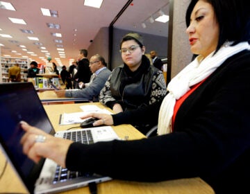 Affordable Care Act health insurance marketplace navigator Leticia Chaw, right, helps gather information for Jennifer Sanchez