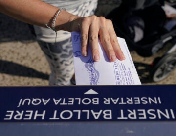 A woman deposits her ballot in an election drop box in Jersey City, N.J.