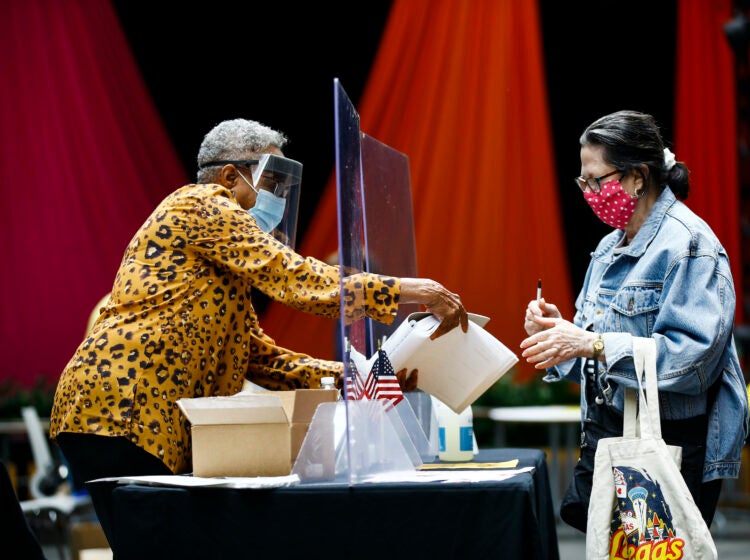 A voter checks in with an election worker before casting her ballot