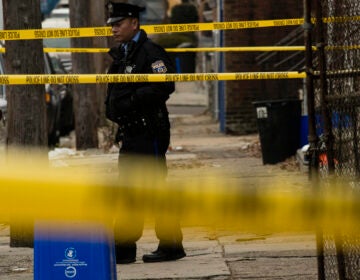 A Philadelphia police officer stands by a crime scene on Woodstock Street