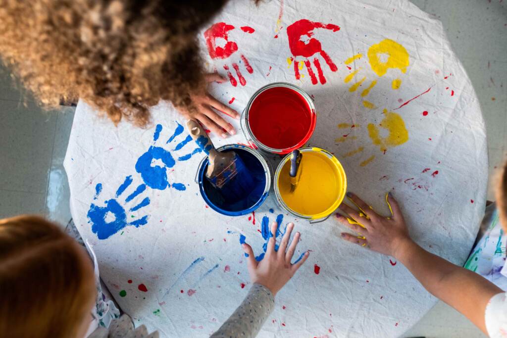 Overhead shot of students placing painted hands on cloth