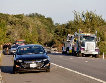 A car and emergency responders by the side of the road.