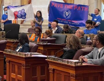 people holding up a banner during city council hearing