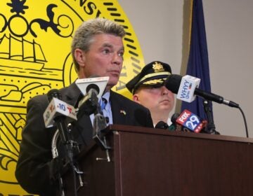 District Attorney Jack Stollsteimer and Chester Police Commissioner Steven Gretzky stand behind a podium