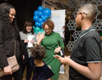 Zora Battle high fives president and CEO of Children’s Scholarship Fund Philadelphia Keisha Jordan while her mother, Zecharia Artemus and her brother, Zaire Denson watch.