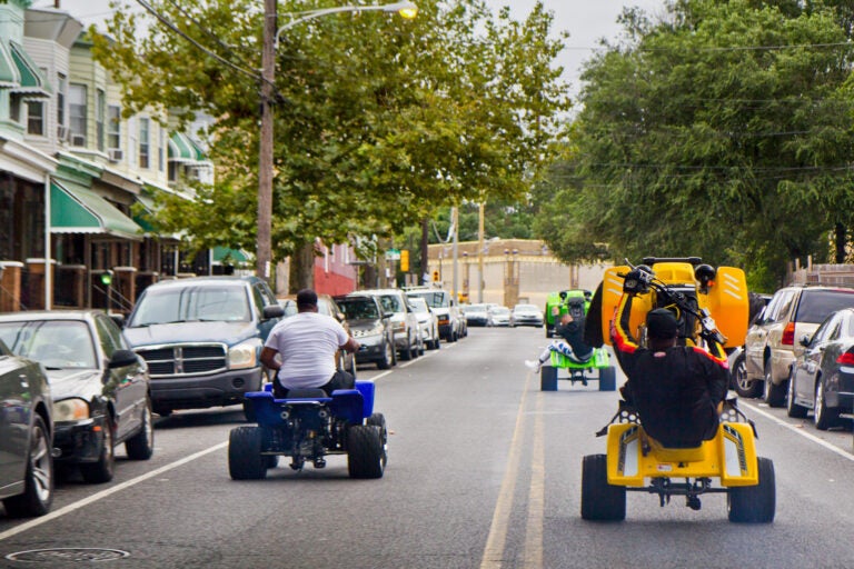 Young people riding ATVs through the streets of Philly. (Kimberly Painter/WHYY)