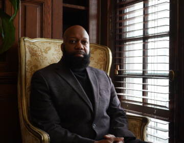 Ed Brown poses for a photo while sitting in a chair