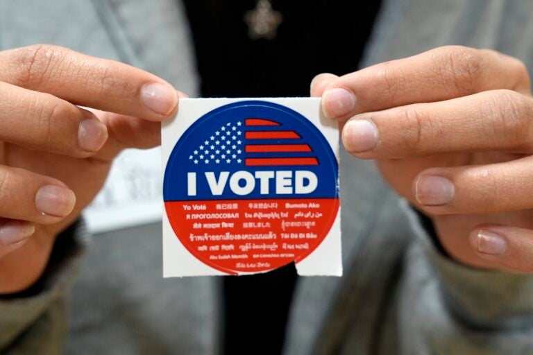 A election volunteer offers voters an 