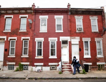 United States Postal Service carrier Henrietta Dixon walks her route to deliver mail in Philadelphia, Wednesday, May 6, 2020. (AP Photo/Matt Rourke)