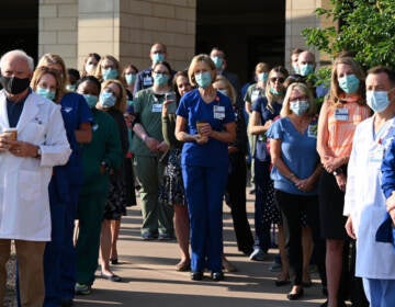 Front-line workers at a medical center in Aurora, Colo., gather for a COVID-19 memorial on July 15 to commemorate the lives lost in the coronavirus pandemic. New estimates say many thousands more will die in the U.S. this summer and fall. (Hyoung Chang/MediaNews Group/Denver Post via Getty Images)