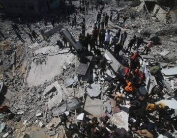 Palestinians look at a residential building destroyed in an Israeli strike in Rafah, Gaza Strip, Tuesday, March 20, 2024.