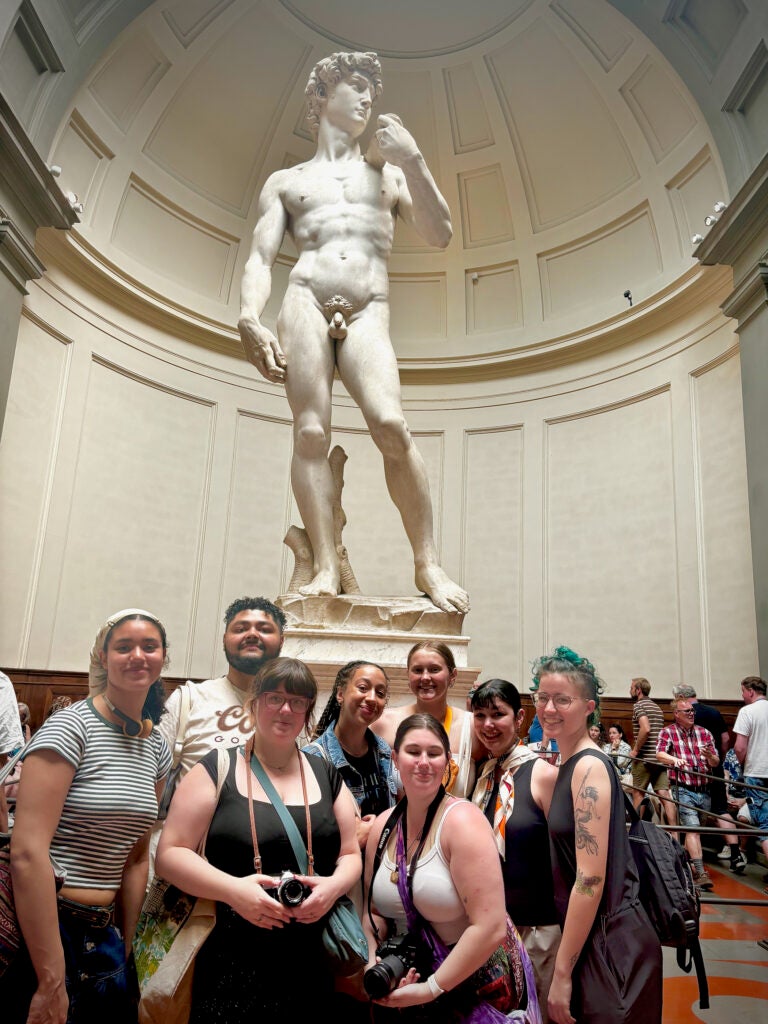 Students posing in front of the statue of David