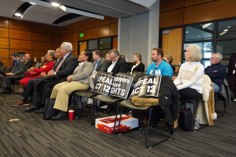 Local water officials and residents alike filled the conference room in West Whiteland and placed signs in the first few seats calling for an appeal of Act 12. (Kenny Cooper/WHYY)