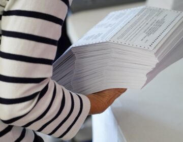 Person holding a large stack of paper