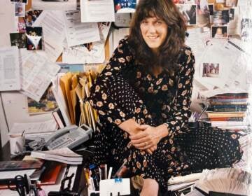 Marty Moss-Coane is seen sitting on a desk in her office