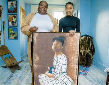 A Black woman and girl with a painting of a young black girl