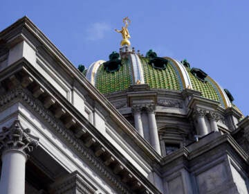 A view from below of the dome of the State Capitol building in Harrisburg, Pa., with blue sky in the background.