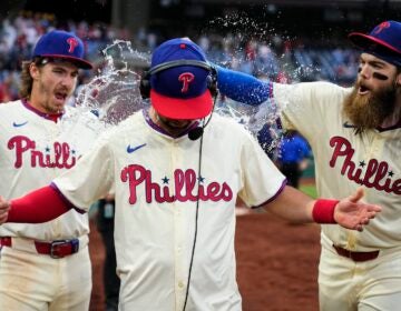 Philadelphia Phillies' Bryson Stott, left, and Brandon Marsh, right, dump water and candy on Whit Merrifield after winning against the San Francisco Giants, Monday, May 6, 2024, in Philadelphia