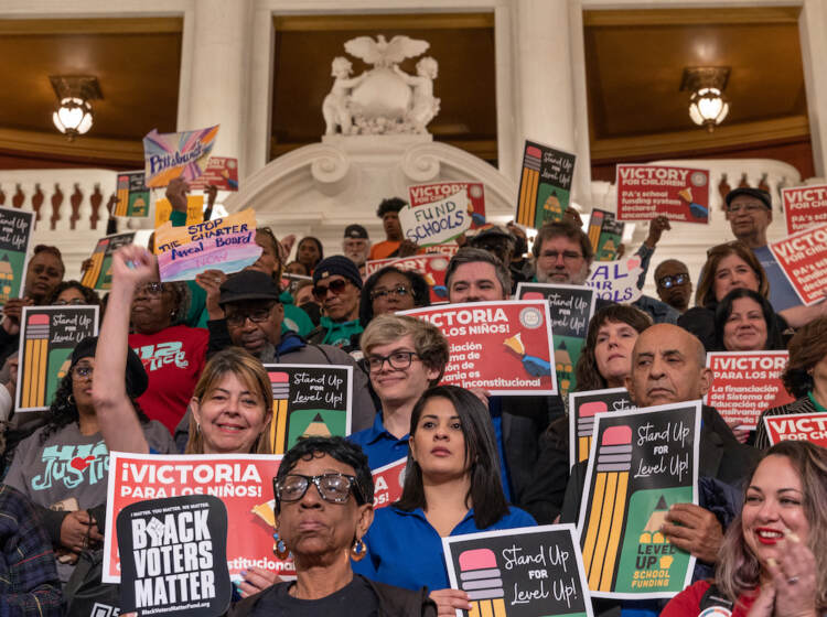 Many people holding signs inside the Capitol building.