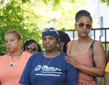 Women gather together and look towards the camera.