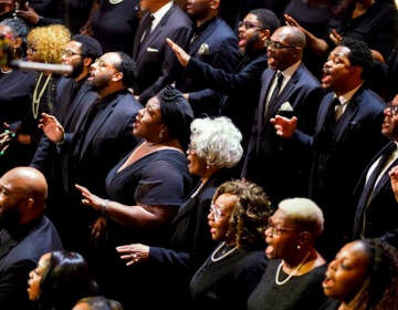 A choir sings, dressed in black.