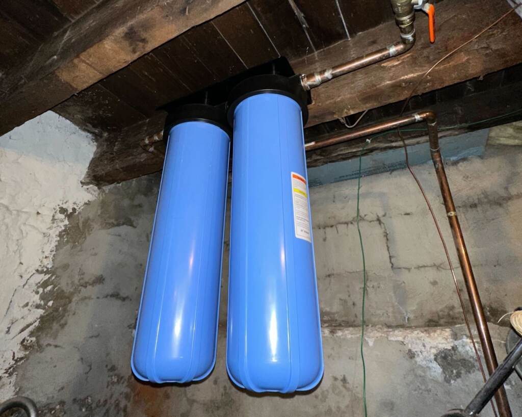 water filtration tanks hanging in a basement.