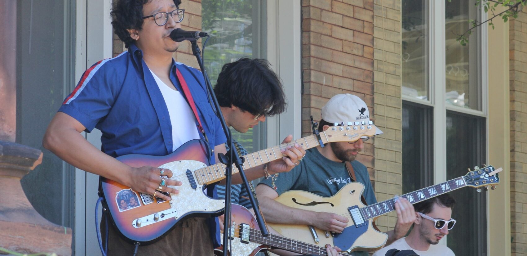 Artists playing guitars and drums and singing