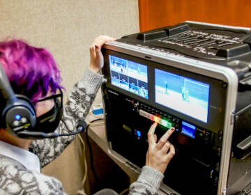 A teenage girl working on a broadcast monitor