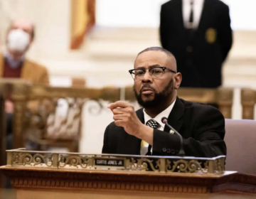 Curtis Jones sits at his desk in City Council Chambers