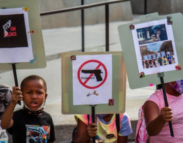 A group of kids from the Southwest Philadelphia Healthnastics program, ages 3-18, held signs at a protest demanding the Kenney administration do more to address gun violence in the city on Aug. 4, 2021. (Kimberly Paynter/WHYY)